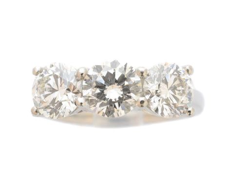 A platinum diamond three stone ring, the brilliant cut diamond line with shared claw settings and tapered shoulders, estimate