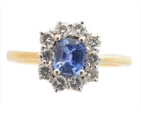 An 18ct gold sapphire and diamond cluster ring, the rectangular shape sapphire within a brilliant cut diamond surround, impor