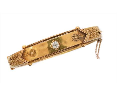 A late Victorian diamond hinged bangle, the old cut diamond inset to the polished bangle, with floral cannetille sides and sp