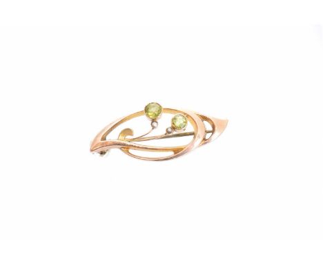 An early 20th century Murrle Bennett & Co. peridot and split pearl brooch, of asymmetric design the circular shape peridot du