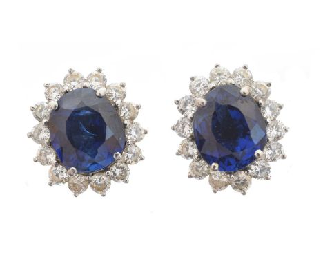 A pair of sapphire and diamond earrings, each designed as an oval shape sapphire weighing approximately 5.50-6cts within a br