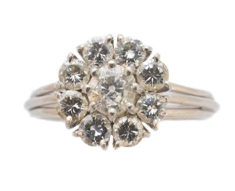 A diamond cluster ring, the brilliant cut diamond within a similarly cut diamond surround with tapered shoulders, stamped PT9