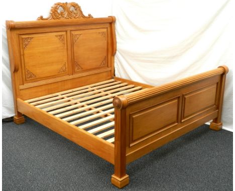 SUPER KING SIZE LIGHT MAHOGANY BED
with carved scrolls above a panelled headboard with a reeded column above a pair of shaped