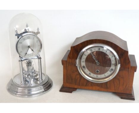 WALNUT MANTLE CLOCK
with a shaped case, the glass door enclosing a silvered chapter ring with a chime/silent lever, standing 