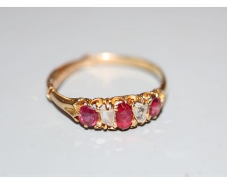 A yellow metal, ruby and diamond set five stone half hoop ring, size P, gross weight 2.2 grams.CONDITION: Two of the rubies h