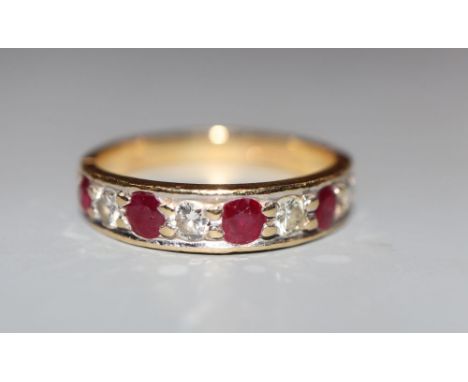 A modern 18ct gold, ruby and diamond set nine stone half hoop ring, size M, gross 3.2 grams.CONDITION: Minor surface scratche