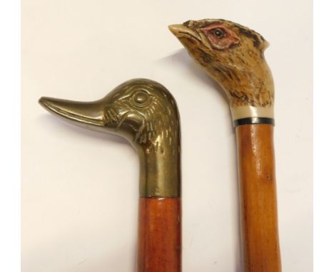 Two walking sticks, comprising a brass duck handled stick and a resin pheasant mounted stick, 93cm long. 