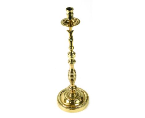 A brass taper candlestick, 47cm high. 