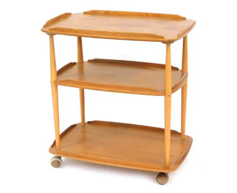 An Ercol light elm three tier trolley, terminating in castors, 77cm high, 69cm wide and 49cm deep.