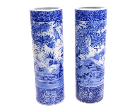 A pair of Japanese blue and white stick stands, each with a bird of prey and floral spray design, unmarked, each 77cm high, 2