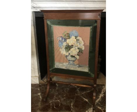 An Edwardian walnut fire screen, with needlework floral panel, 106cm high, 67cm wide. 