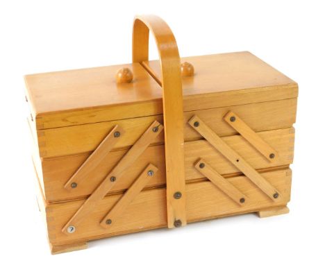 A beech cantilever sewing box, with shaped handle on bracket feet, 26cm high, 32cm wide, 19cm deep.