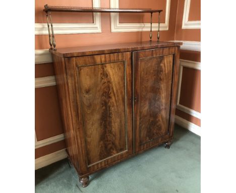 A Regency flame mahogany chiffonier, with a brass galleried top and shelf with turned brass supports, two door cabinet base o