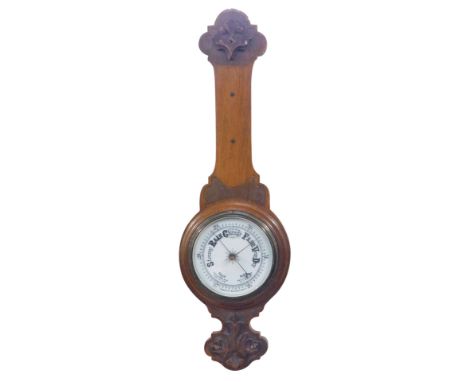 An early 20thC oak cased aneroid barometer, with applied and carved top, white ceramic dial, 73cm high. (AF)