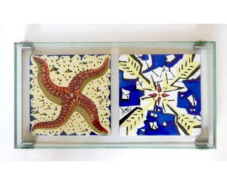 Two decorative ceramic tiles after Dali (1954) mounted in a glass display case Condition ReportA couple of small glaze chips 