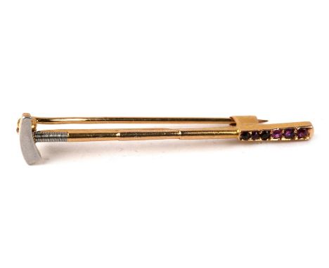 An 18ct gold and ruby novelty bar brooch modelled as a polo mallet, unmarked but tested,  2.3g. 4.3cm (14.75 ins) wide,