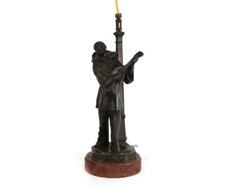 A bronzed spelter table lamp in the form of a Pierrot standing in front of a lamp post, 37cms (14.5ins) high.