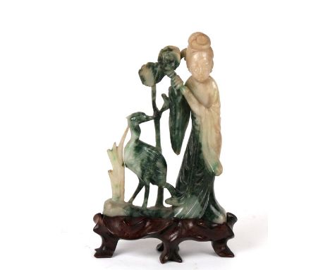 A green and white Chinese jade figure of Guanyin with lotus and a crane on a wooden stand. 14cm (5.5 ins) high.