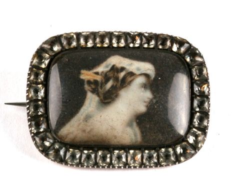 An early Victorian gold mourning brooch, set a glazed en grisaille portrait within a border of pastes, the rear engraved with