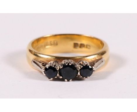 An 18ct gold three stone sapphire ring, approx UK size 'K'. 5.6g