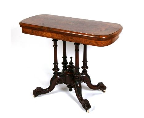 A Victorian inlaid figured walnut card table on turned supports and quatrefoil base, 93cms (36.5ins) wide.