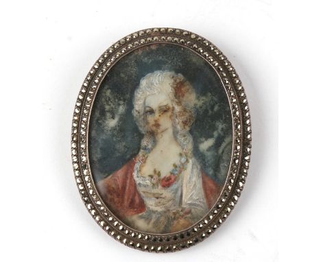 A silver and marcasite oval brooch containing a watercolour portrait miniature of a young woman