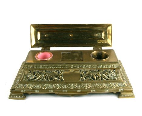 A Victorian brass desk stand with pierced foliate decoration, 38cms (15ins) wide.Condition ReportOne of the ceramic inkwells 