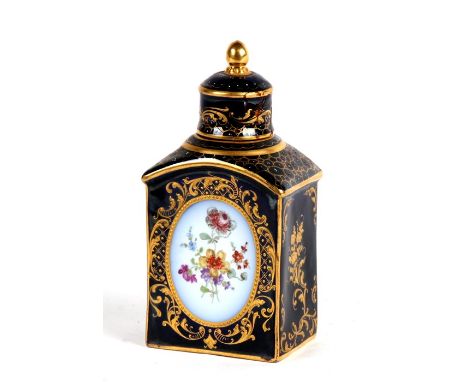 A Dresden porcelain tea caddy decorated with flowers within oval panels with gilt highlights, on a deep blue ground, 15cms (6