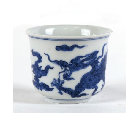 A Chinese blue &amp; white tea bowl decorated in the Ming style, with a dragon amongst clouds, 66cms (2.25ins) high, together