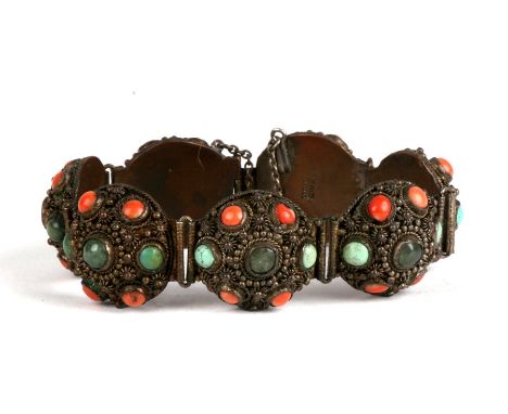 A Chinese seven panel bracelet, each set with central jade cabochon within a border of turquoise and coral cabochons. Each pa
