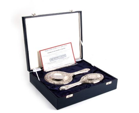 A cased silver dressing table set to include a hairbrush, hand mirror and comb.