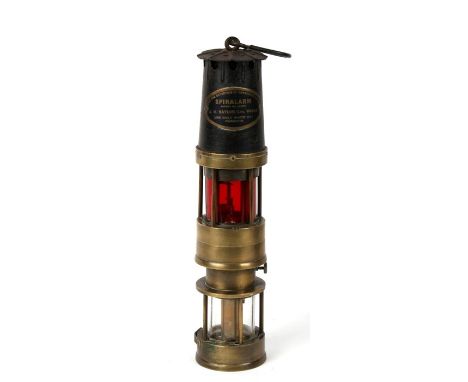 A Spiralarm miners lamp for the detection of dangerous gases. Clear glass lamp base with red alarm lamp section above. Made b