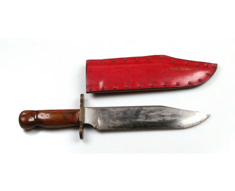 A large Bowie knife having hardwood grips and a brass crosspiece in its leather scabbard. No makers name. Blade length 25.5cm