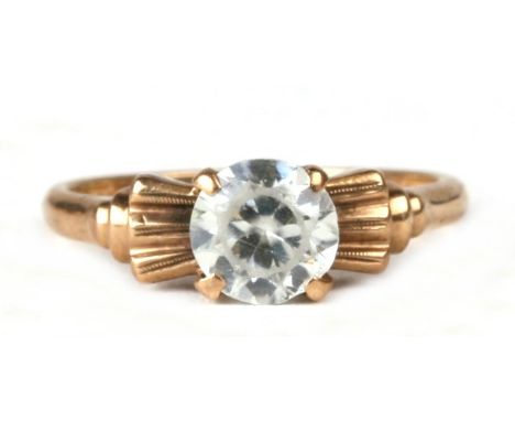 A 10ct gold dress ring set with a single large white stone, possible a white sapphire, approx UK size 'K'.