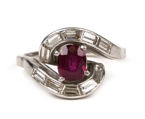 An 18ct white gold (tested) ruby &amp; diamond ring set with a large central oval ruby surrounded by channel set baguette dia