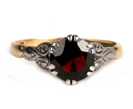 An 18ct gold and platinum ring set with a large garnet, approx UK size 'K'.