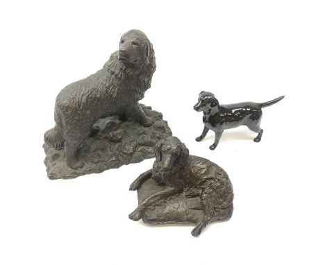 A Beswick figurine, modelled as a black Labrador, with printed mark beneath, together with two resin figures modelled as dogs