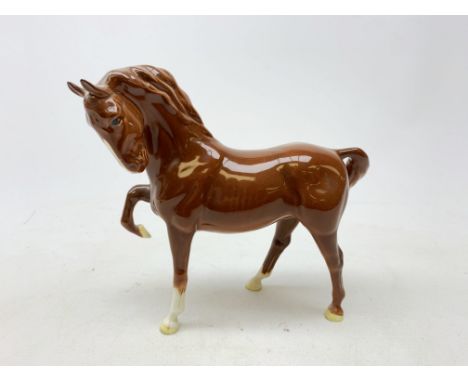 A Beswick figurine, modelled as a chestnut horse with front leg raised, with printed mark beneath, H19cm.  Condition Report C