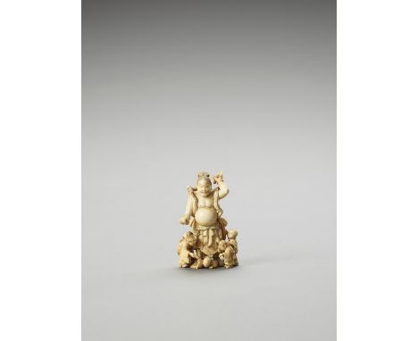   AN IVORY OKIMONO OF A NIO STATUE AND CHILDREN  Signed  Japan, Meiji period (1868-1912)    The guardian statue holding a kon