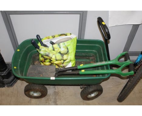 Green plastic four wheel trolley, two spades and bag of tools 