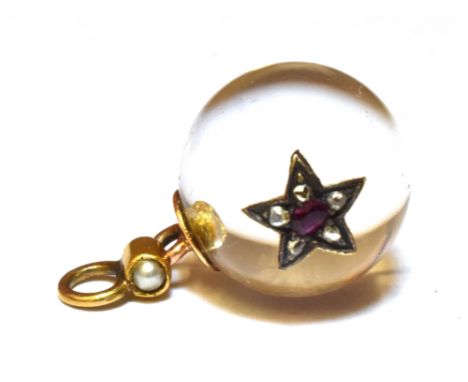 A ROCK CRYSTAL SMALL SPHERE PENDANT  Inset with a star set with a small ruby and diamonds, seed pearl set gold loop bale to t