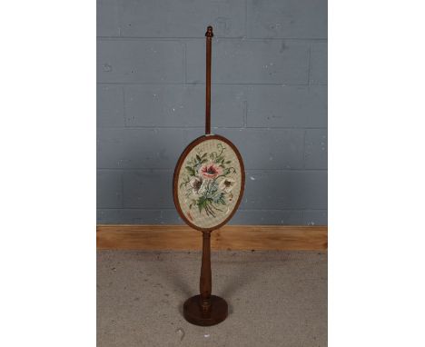 Edwardian mahogany and needlework fire screen, the oval needlework screen depicting flowers together with a octagonal bulbous