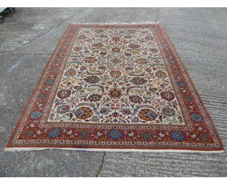 Persian wool carpet floral and leaf decorations in reds and blues against a cream ground, 330 x 234cm