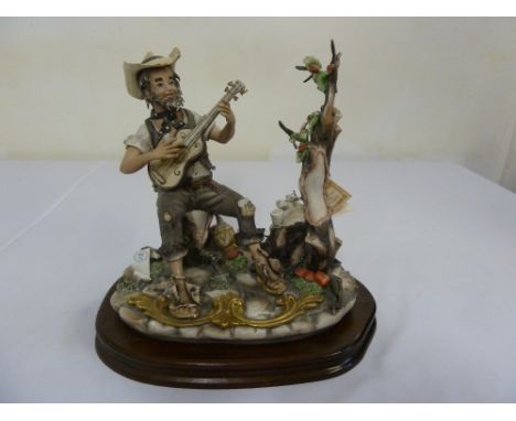 Capodimonte figural group of a man playing a guitar