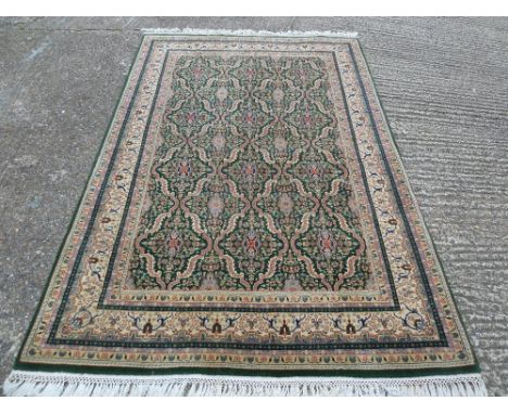 Persian wool carpet with geometric patterns mainly greens and browns, 272 x 178cm