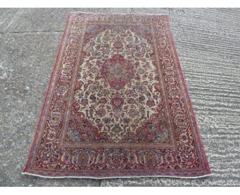 Persian wool carpet predominantly reds and beige with scrolls and flowers, 202 x 131cm