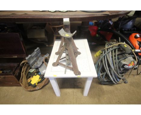 A pair of axle stands together with a small white painted wooden table with tile top
