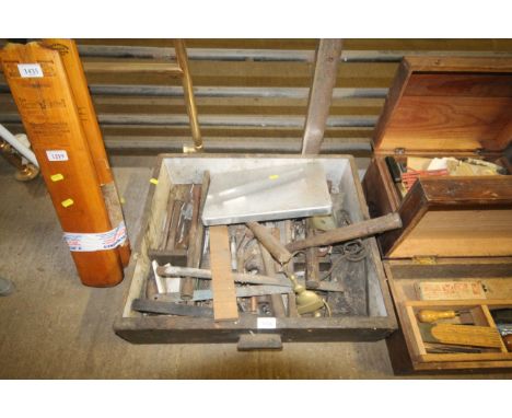A wooden box containing a quantity of tools including hammers, saw blades, pliers etc 