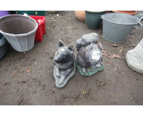 Two concrete garden ornaments in the form of a laying dog and seated squirrel 