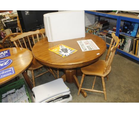 An oak circular dining table and four stick back chairs 